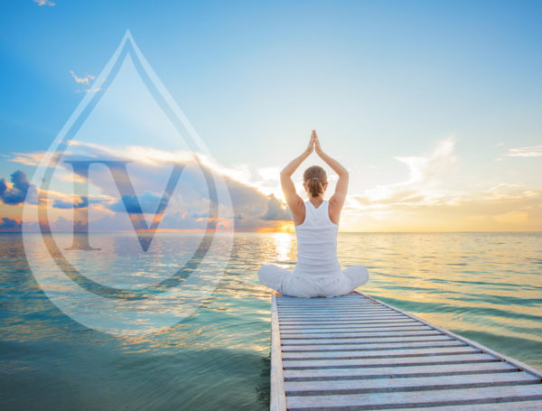 a woman doing yoga on a dock overlooking the water