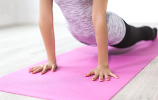 a woman doing a yoga pose on a pink yoga mat