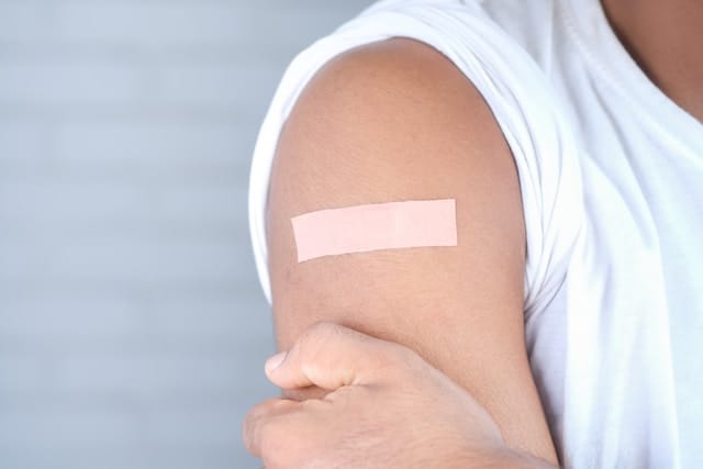An arm with a bandage after an injection