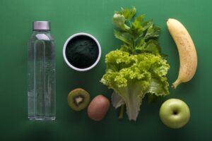 a water bottle next to some fruits and vegetables