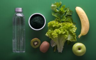 a water bottle next to some fruits and vegetables