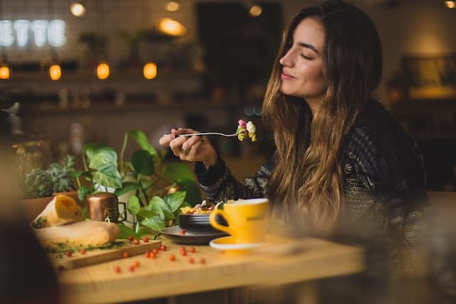 Happy-looking woman eating food at a table