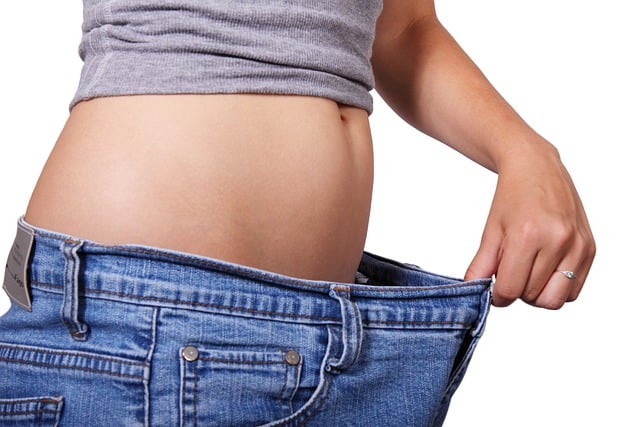 Woman Checking Waist Size on Jeans After Losing Weight