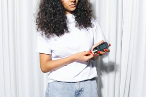 Woman holding a glucometer against a white background