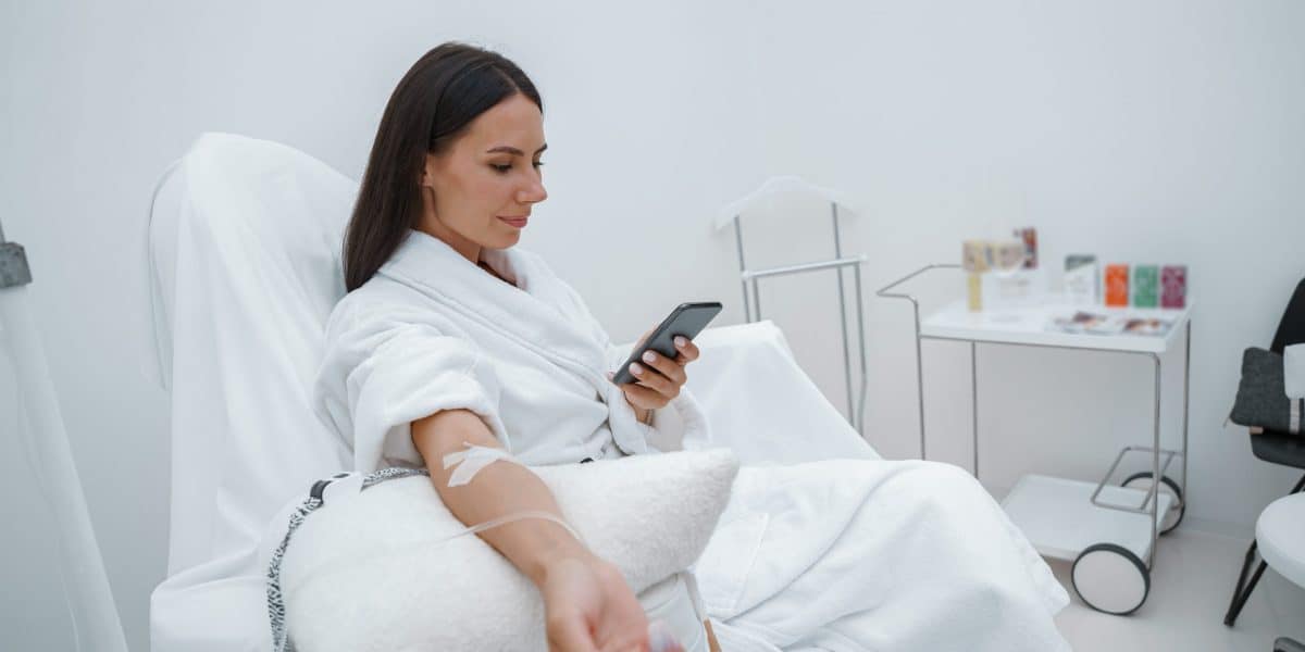 Girl on her phone with IV