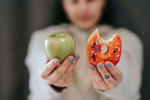 Out-of-focus woman holding an apple and donut