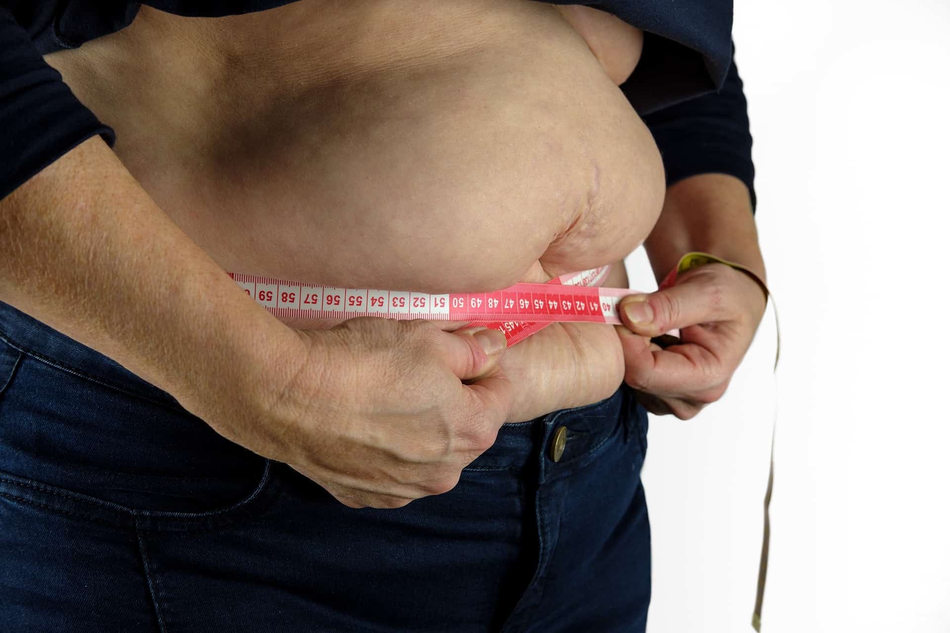 A Man Measuring Their Belly With a Tape Measure