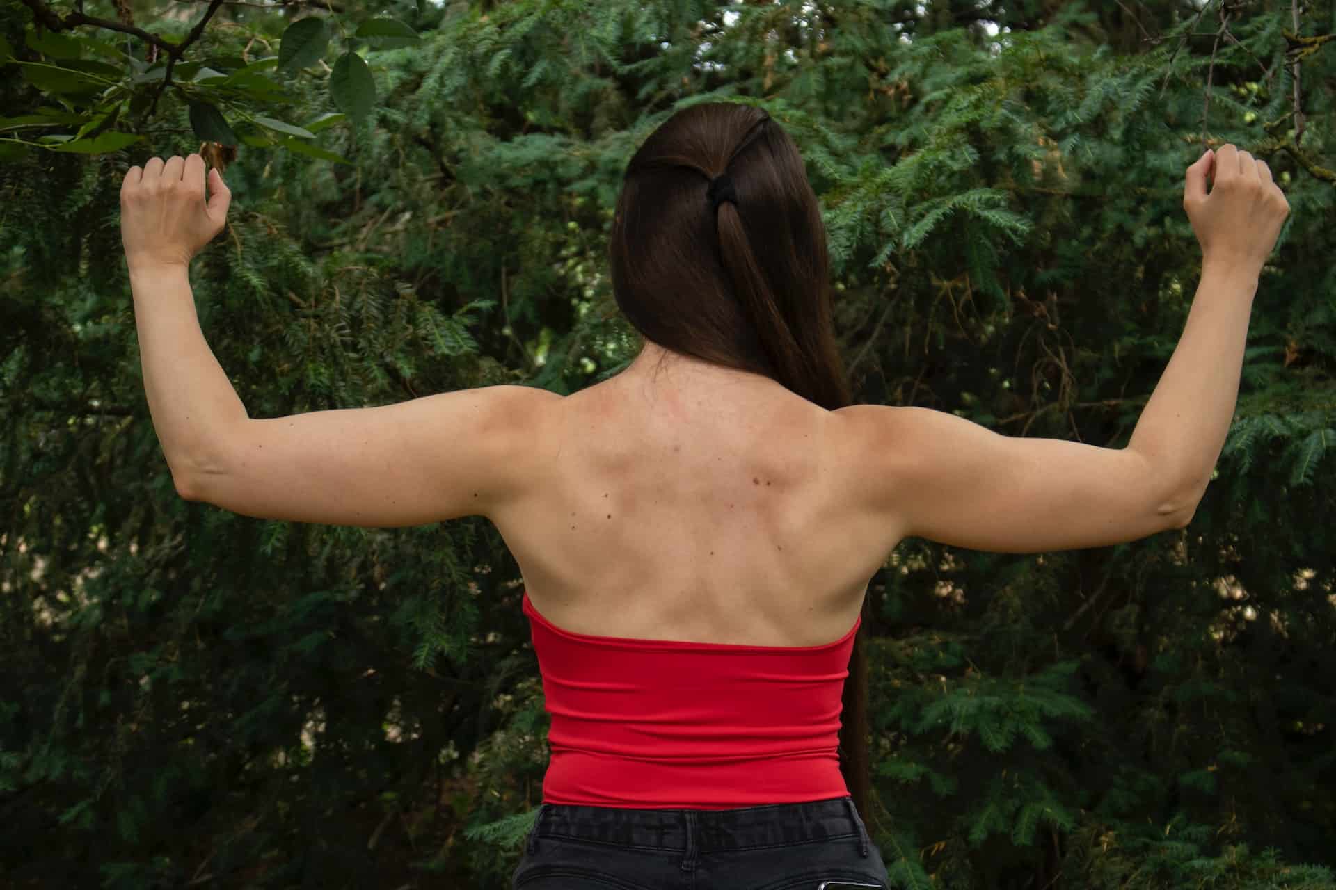 Woman with a muscled-back raising her arms