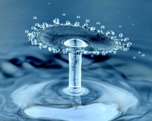 Close-up of a water droplet with the top moving upwards