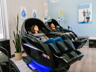Couple man and woman relaxing in massage chair and getting a vitamin infusion therapy