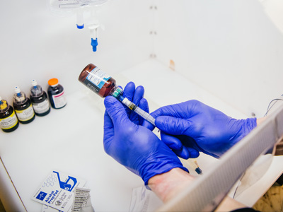 Experienced infusion specialist compounding an iv bag with revitalizing vitamin therapy
