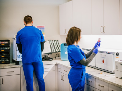 Two medically specialized infusion specialists making IV and vitamin injection treatments for Prime IV client