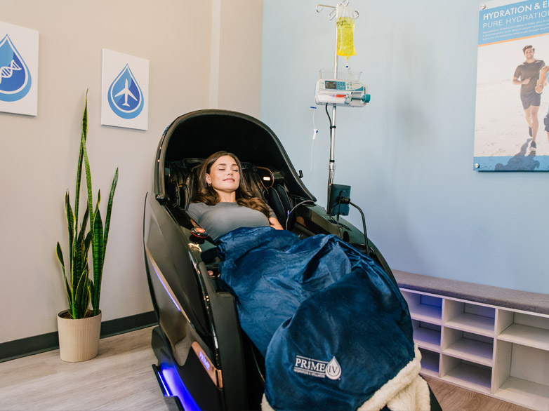 Relaxed woman in vip massage chair getting a iv therapy vitamin infusion