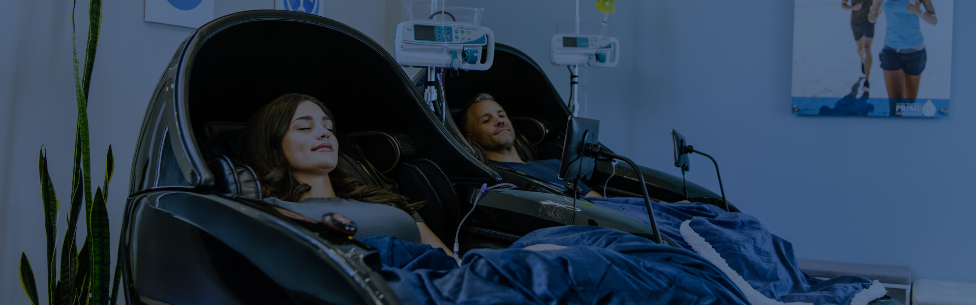 Man and Woman getting IVs and relaxing in massage chairs at Prime IV