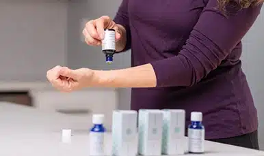 Woman applying organic topical oil hormone therapy